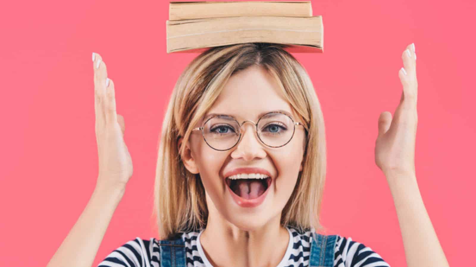 Portrait of happy young student in eyeglasses with books