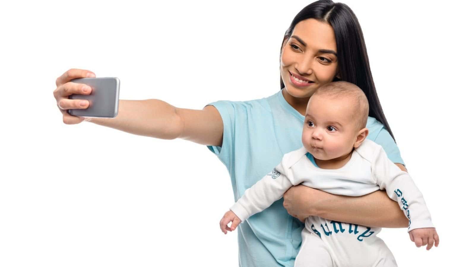 Portrait of smiling mother taking selfie together with little baby