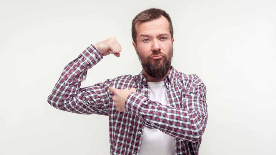 Proud Bearded Man Pointing on His Biceps