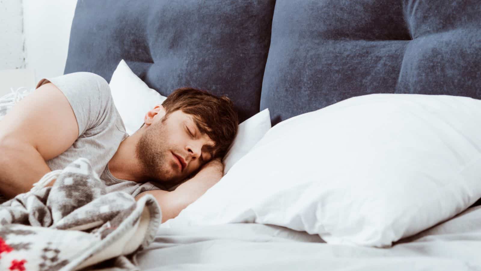 Selective focus of young man sleeping in bed at home