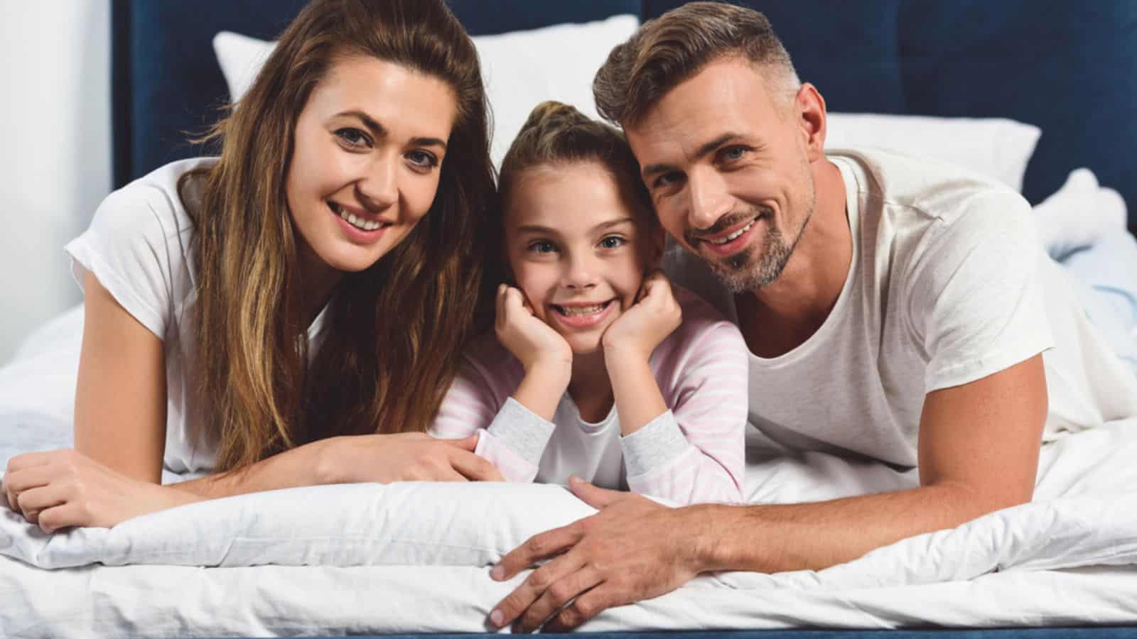 Smiling family laying in bed together