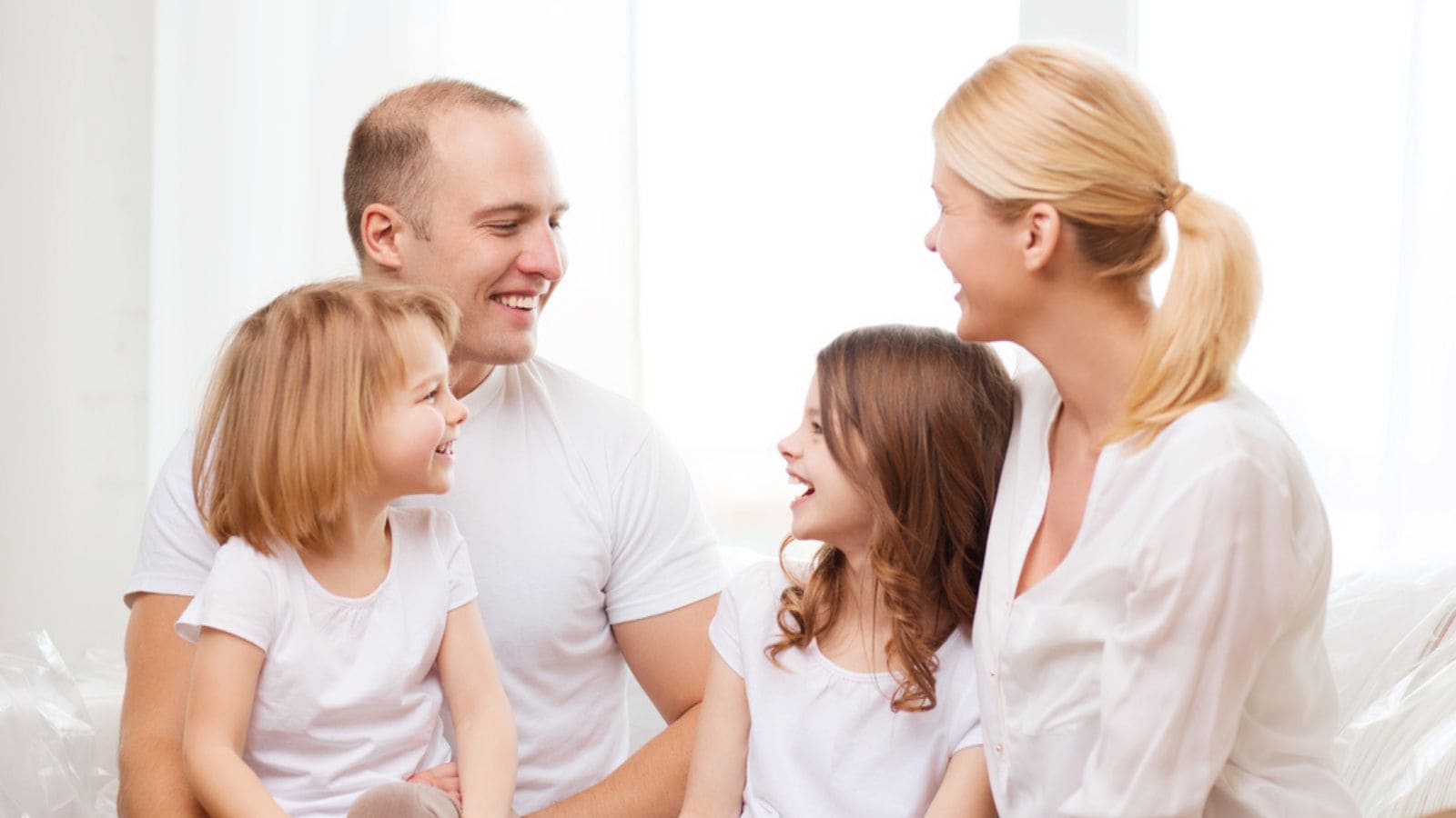 Smiling family with two little girls at home