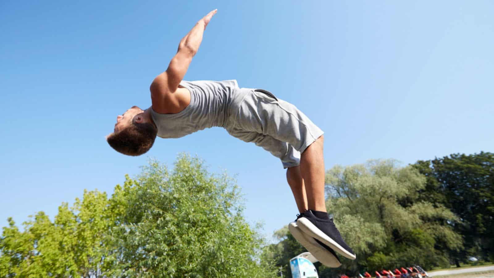Sporty young man jumping in summer park