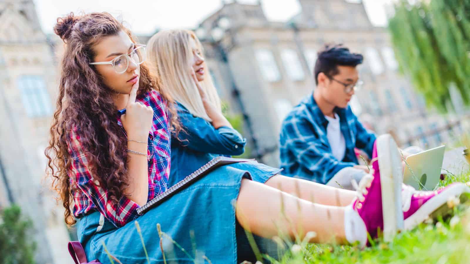 Students sitting on green grass in park