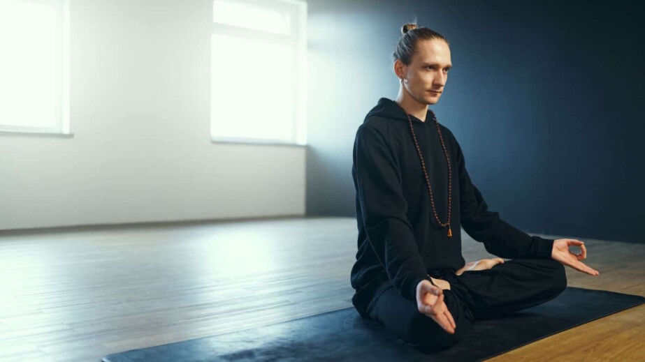 The Man Sits on the Mat in the Lotus Position