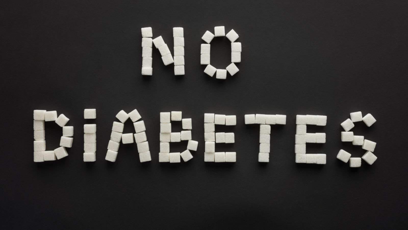 Top view of "no diabetes" lettering made of sugar cubes