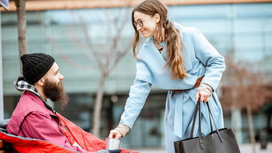 Woman Giving Money for a Homeless Beggar