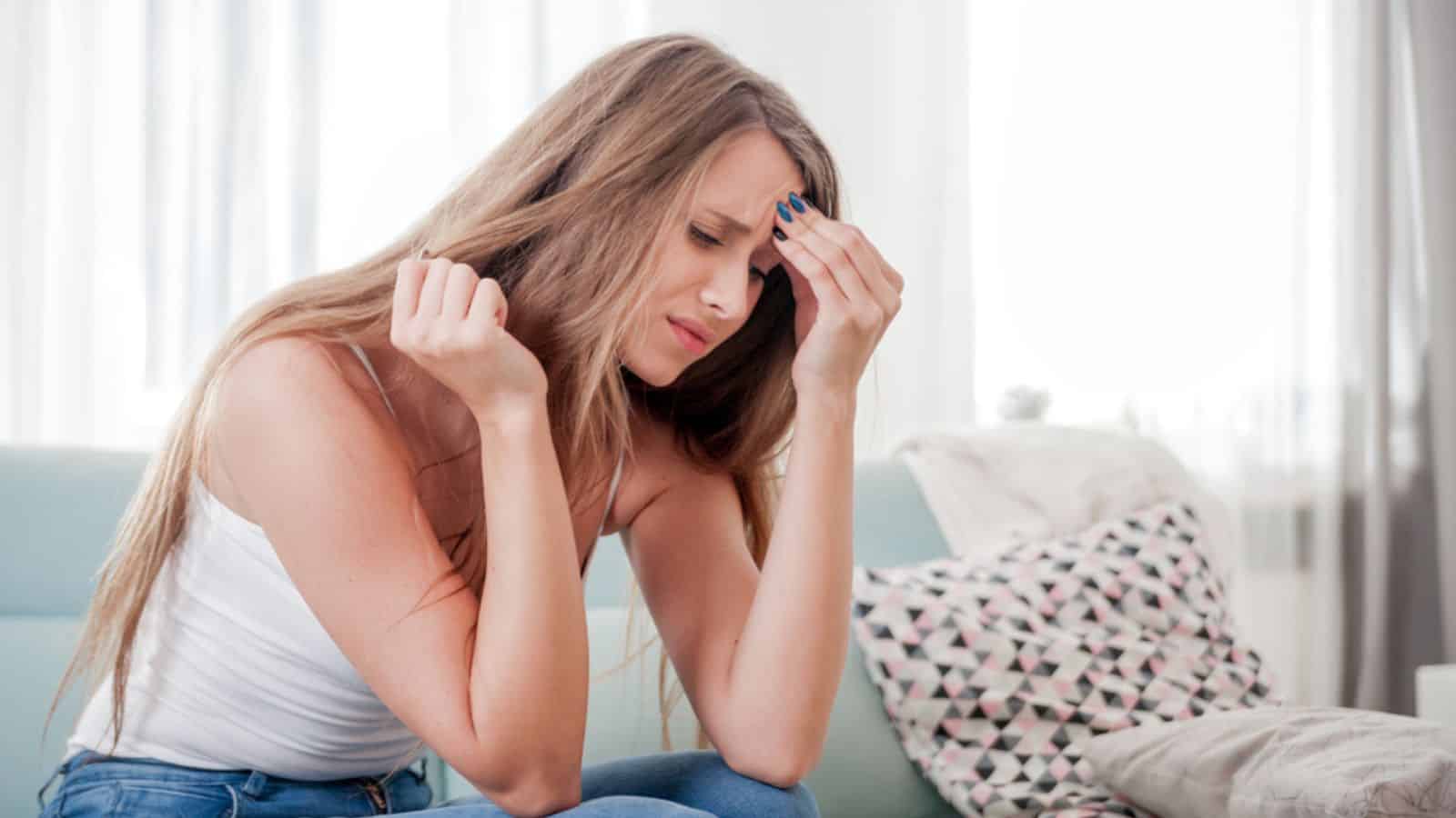 Woman at home suffering from headache, emotions and stress