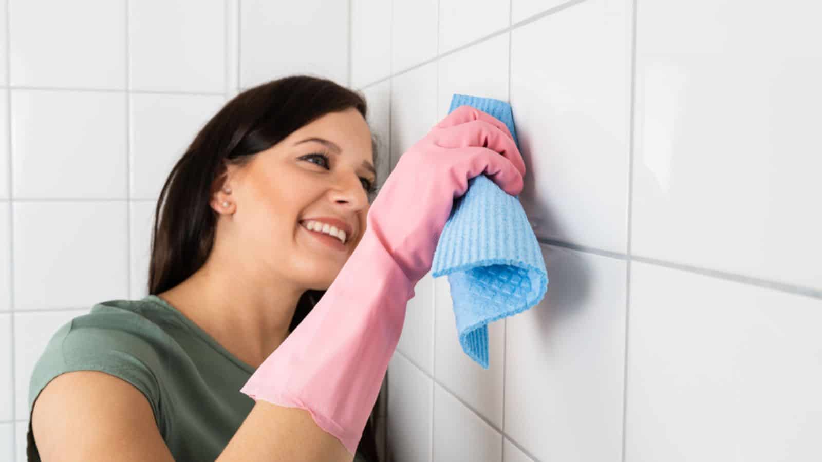 Woman cleaning the tiles in the bathroom