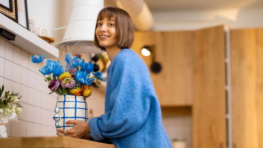 Woman decorates home interior with flowers
