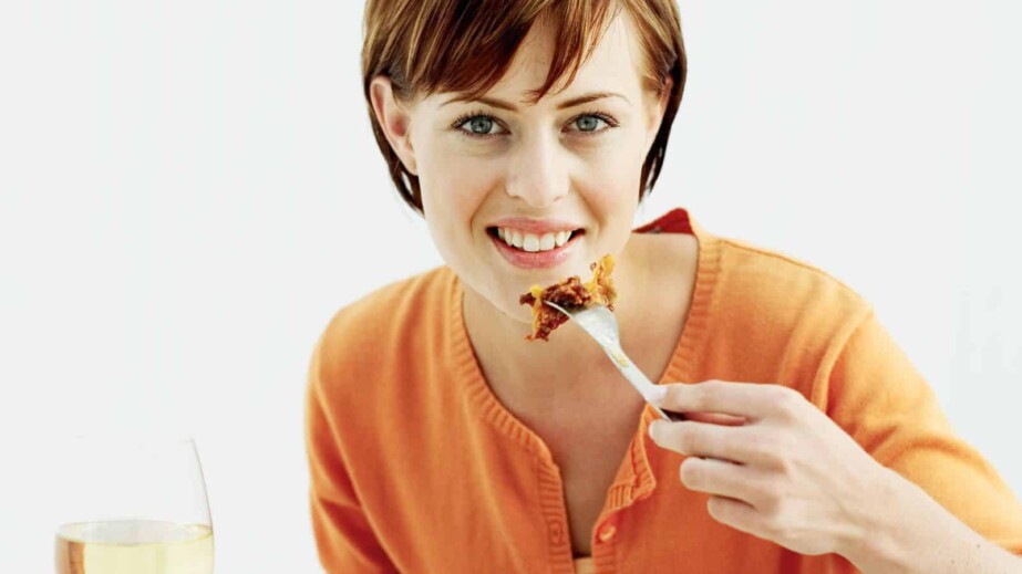 Woman eating lasagna