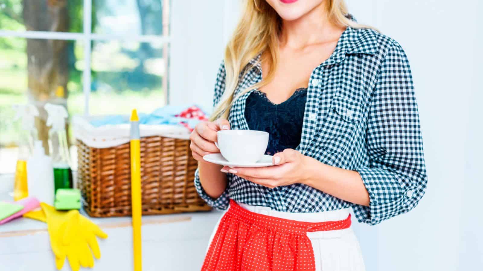 Woman having coffee break after cleaning the house