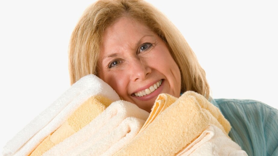 Woman holding stack of towels
