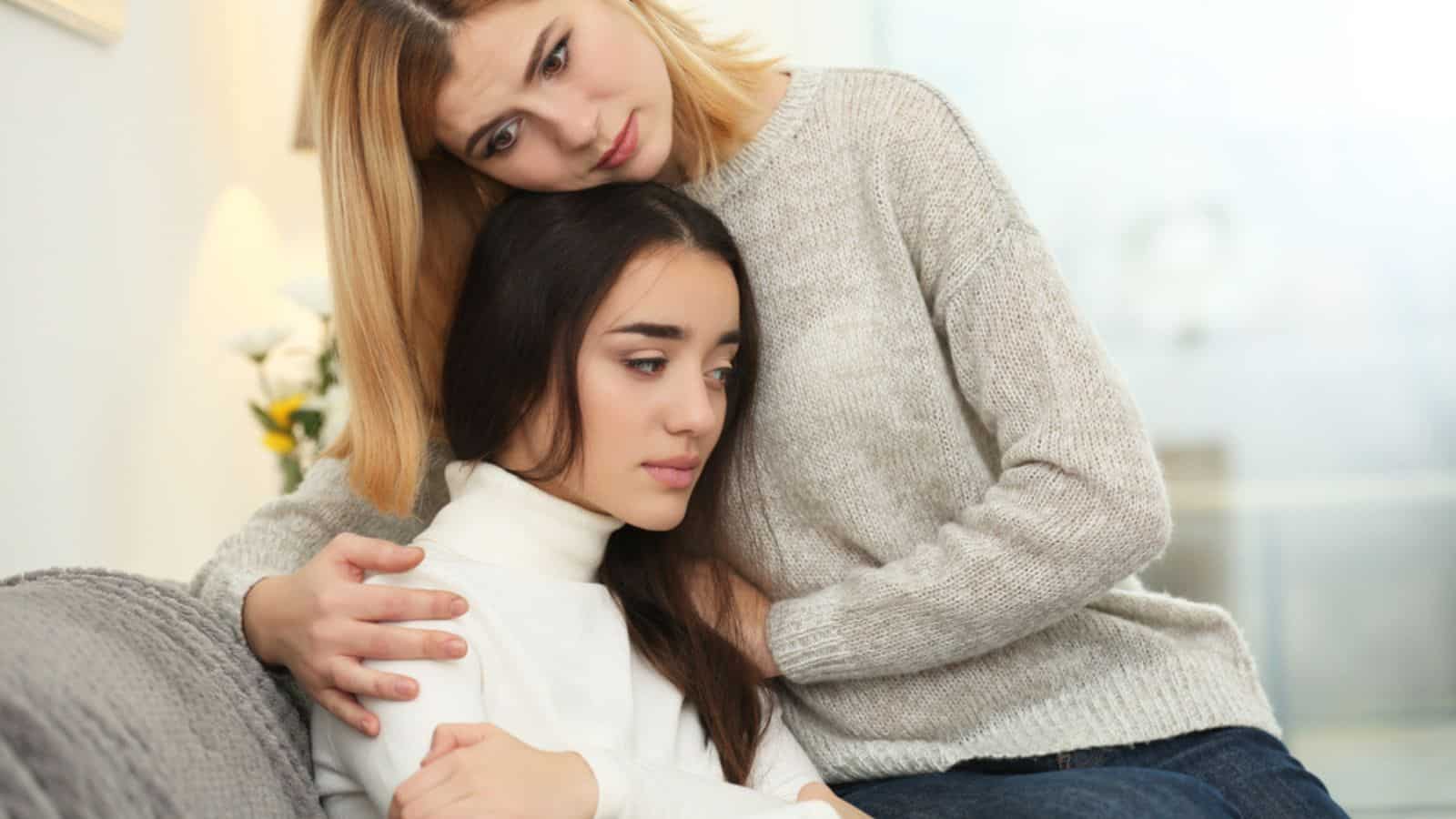 Woman hugging depressed friend