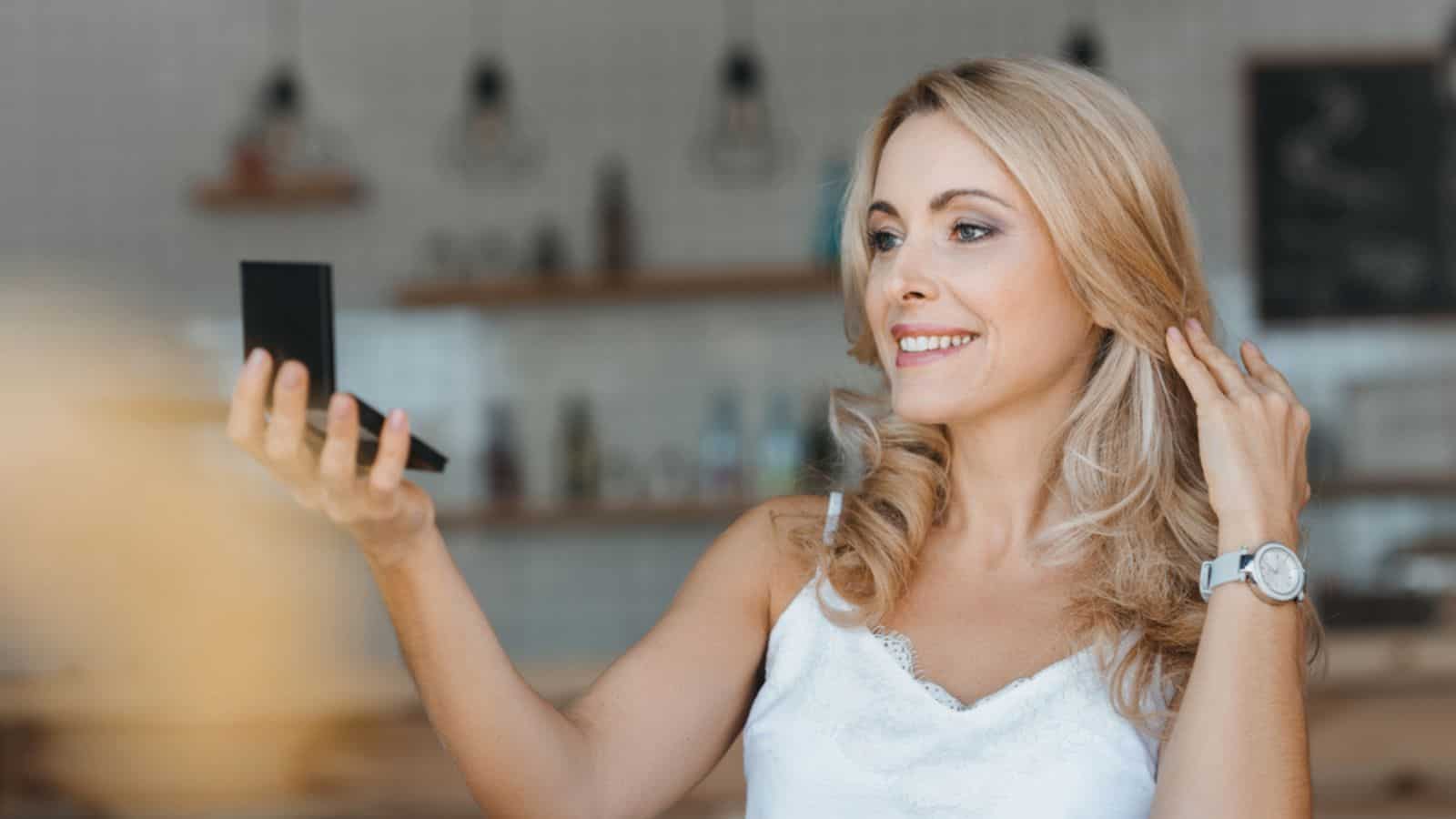 Woman looking at cosmetic mirror