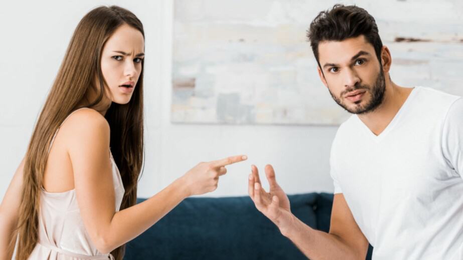 Young attractive woman pointing with finger angrily at man