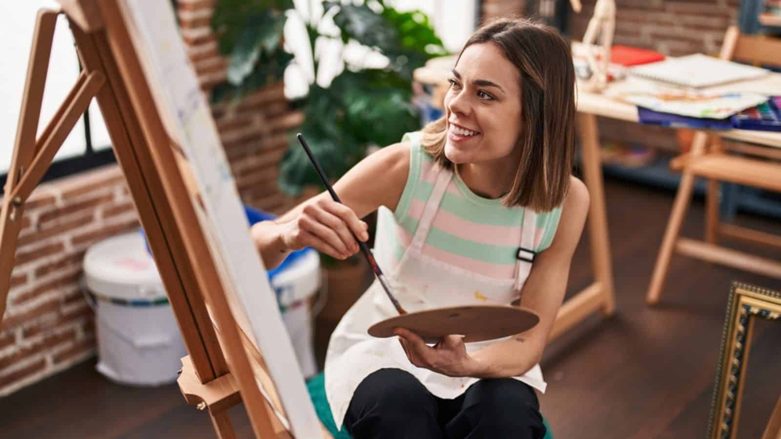 Young beautiful hispanic woman artist smiling confident drawing at art studio