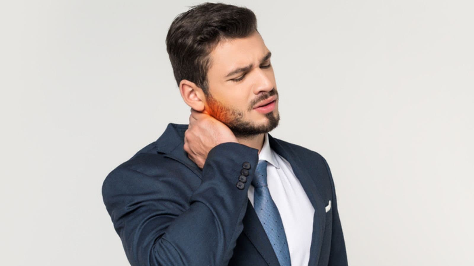 Young businessman with closed eyes suffering from pain