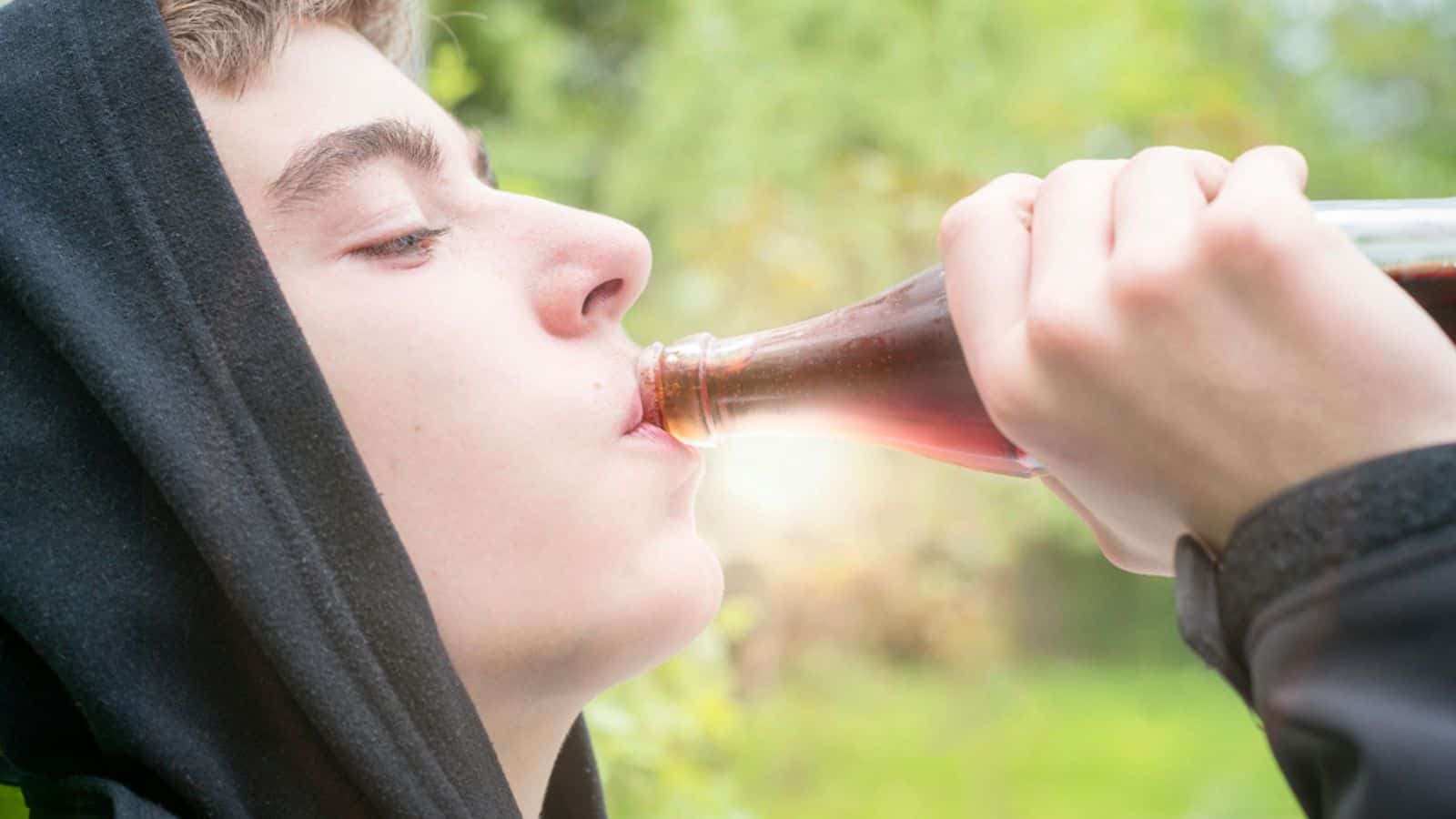 Young man with hoodie drinking a cola