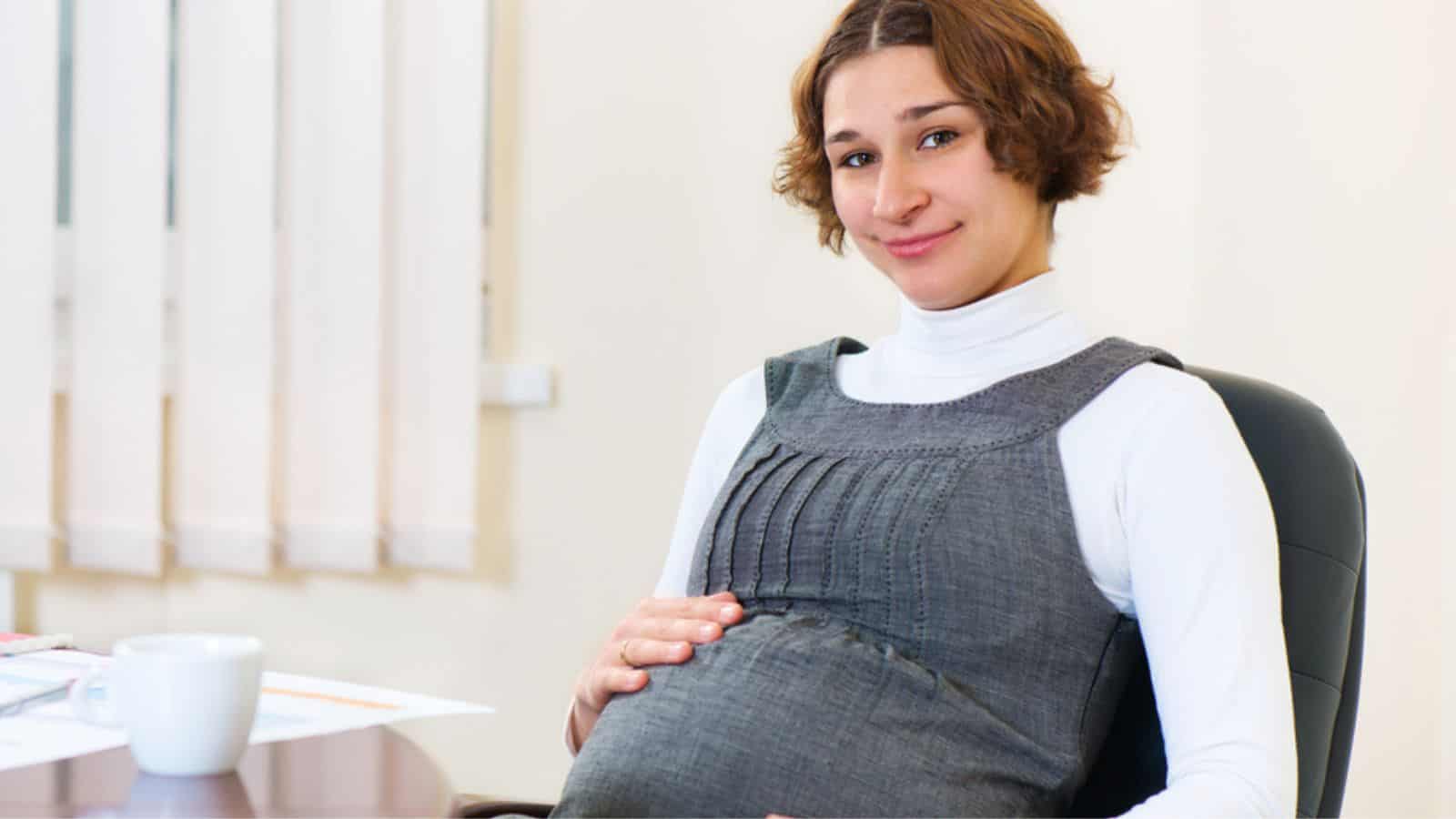 Young pregnant woman at office