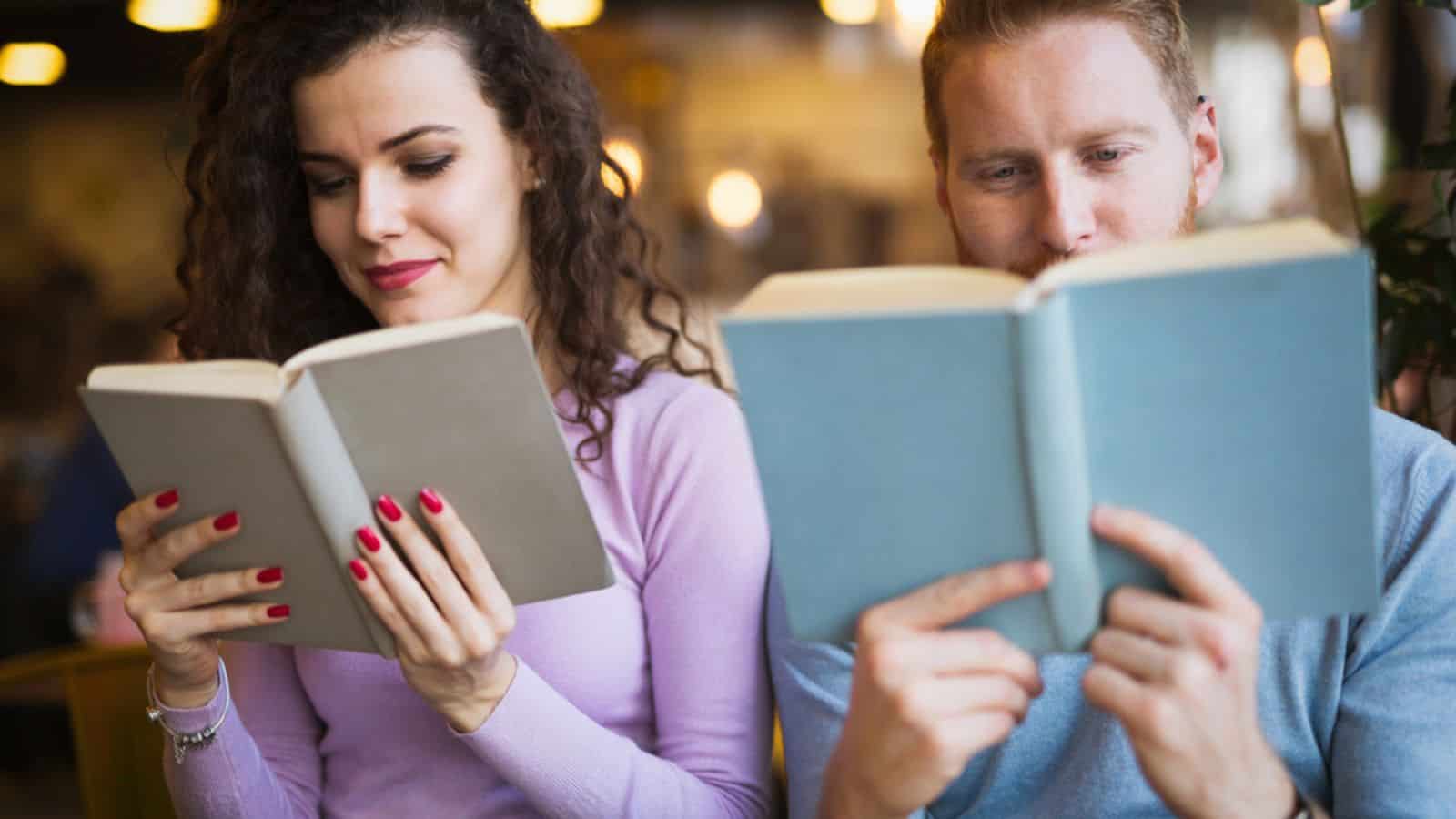 Young woman and man students reading books