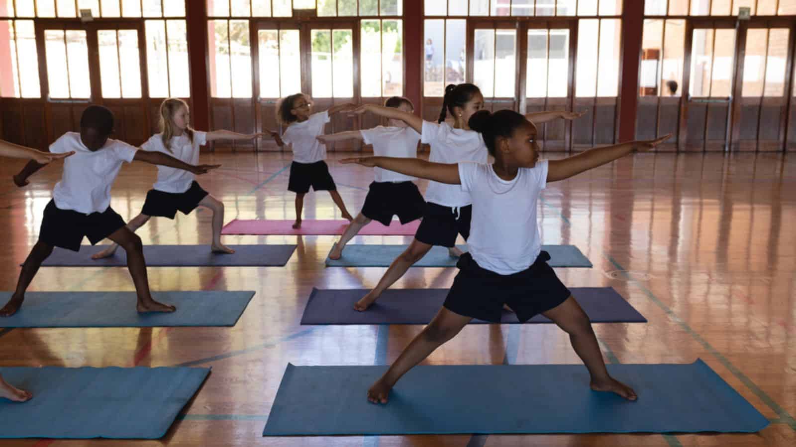 school kids doing yoga on a yoga mat in school